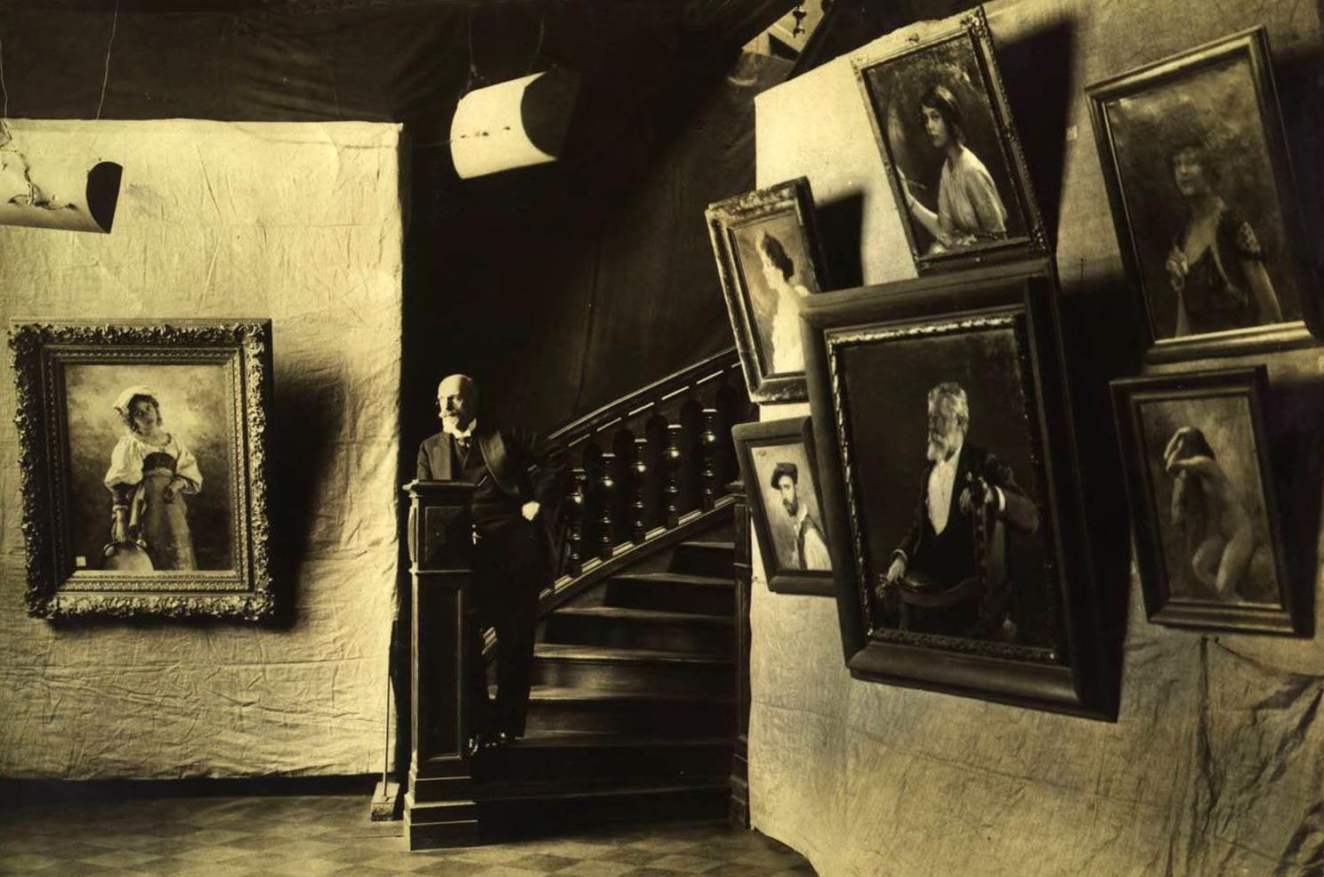 Victor Karlovich Stember is shown amongst his paintings in 1913 at the 25th Anniversary Celebration